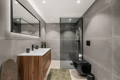 a bathroom with a toilet and a sink and a shower at Grand Junior Suite in Molde