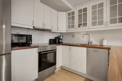 a kitchen with white cabinets and stainless steel appliances at 3 soverom, sentralt i Bergen og moderne bad in Bergen