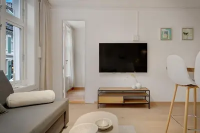 a living room with a couch and a tv on a wall at 3 soverom, sentralt i Bergen og moderne bad in Bergen