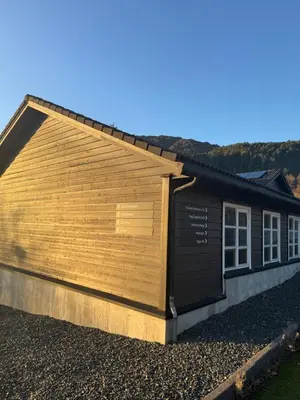 a large wooden building with a sign on the side of it at Siggjo Guesthouse Bømlo and Stord in Mosterhamn