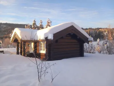 a log cabin with snow on top of it at Krøderen Laftet tømmerstue fra 2021