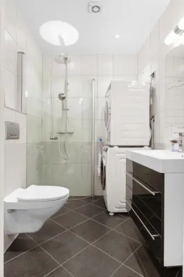 a white bathroom with a toilet and a shower at Perfect Location by Bryggen in Bergen
