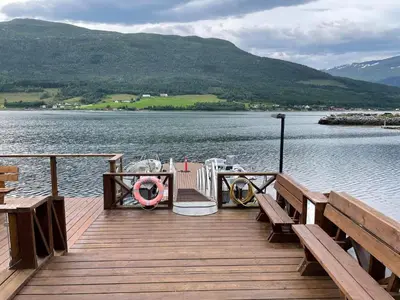 a dock with a boat on the water at 4 star holiday home in Eidsvåg in Eidsvåg