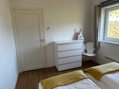 a bedroom with a bed and a dresser and a window at 4 star holiday home in Eidsvåg in Eidsvåg