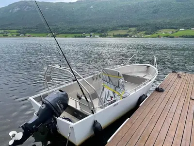 a boat tied up to a dock on a lake at 4 star holiday home in Eidsvåg in Eidsvåg