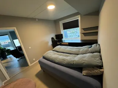 a bedroom with a bed and a window in a room at Family-friendly luxury penthhouse with three bedrooms in Stjoerdal