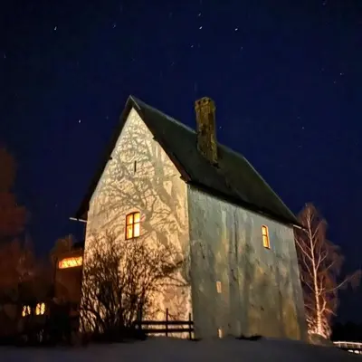 an old stone church in the snow at night at Leilighet I låve in Gran
