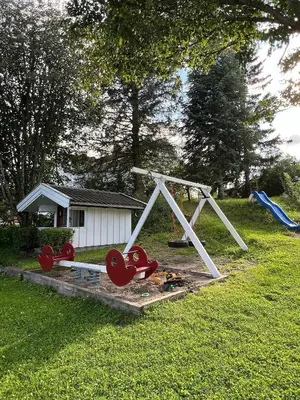 a playground with a swing set in a yard at Leilighet I låve in Gran