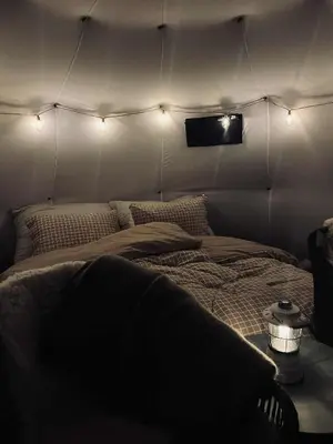 a room with a bed in a tent with lights at Torshaug glamping in Trondheim