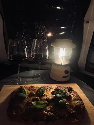 a pizza on a table with two glasses of wine at Torshaug glamping in Trondheim