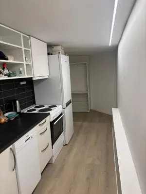 a small kitchen with white appliances and wooden floors at Family friendly apartment with parking in Bergen