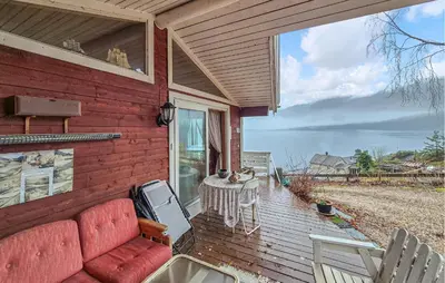 a red couch sitting on the back of a house at Nice Home In Vallavik With Wifi in Kaland