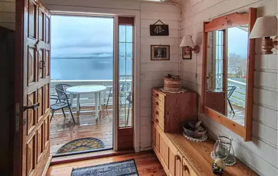 a room with a door and a balcony with a table at Nice Home In Vallavik With Wifi in Kaland
