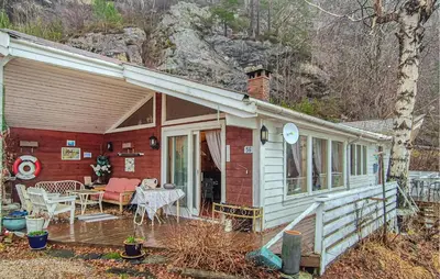 a small house with a porch and a table at Nice Home In Vallavik With Wifi in Kaland