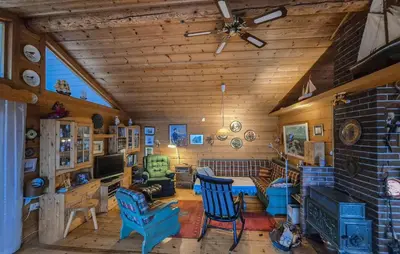 a living room with blue chairs and a fireplace at Nice Home In Vallavik With Wifi in Kaland