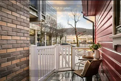 a balcony with a white fence and chairs and a table at Sentralt,unikt lite bergenshus med sjel på fine Nøstet! in Bergen