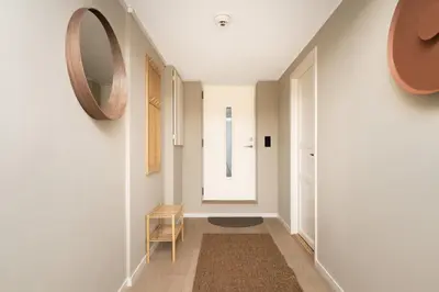 a hallway with a mirror and a chair at Bright & Stylish Apartment in City Center in Bergen