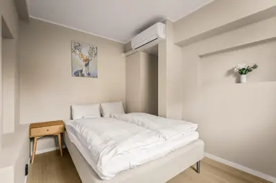 a white room with a bed and a table at Bright & Stylish Apartment in City Center in Bergen