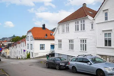 two cars parked on a street with white buildings at Bright & Stylish Apartment in City Center in Bergen
