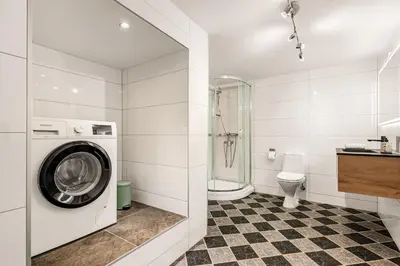 a bathroom with a washing machine and a toilet at Bright & Stylish Apartment in City Center in Bergen