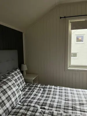 a bedroom with a checkered bed and a window at Your home in Kristiansund in Kristiansund
