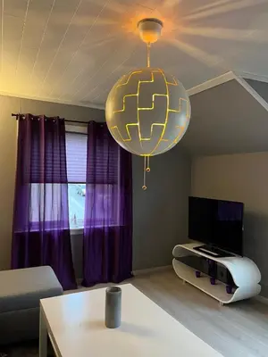 a living room with purple curtains and a chandelier at Your home in Kristiansund in Kristiansund