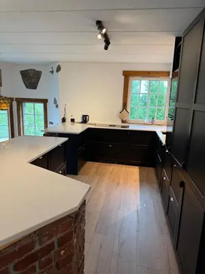 a kitchen with white counter tops and wooden floors at Haven Fortress