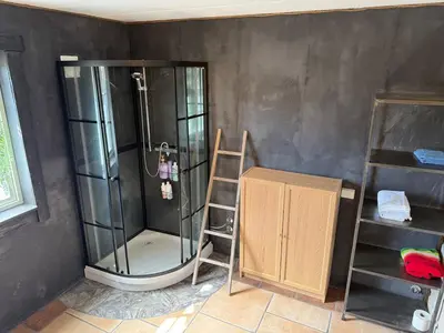 a shower in a room with a ladder and a shelf at Haven Fortress