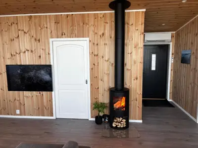 a fireplace in a room with wooden walls at Unik og moderne hytte med utsikt mot havet 38 in Haram