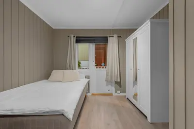 a bedroom with a white bed and a window at Apartment in idyllic Kristiansund in Kristiansund