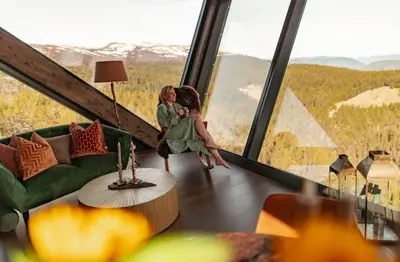two women sitting in a room with a large window at Eagle Nest Eco Lodge in Sel