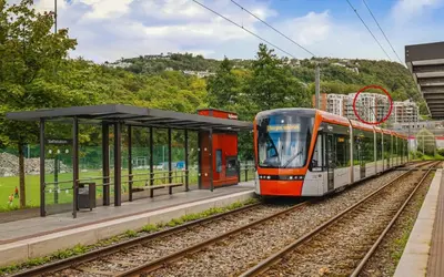 a train is pulling into a train station at Convenient Bergen Stay with Easy Transport Connections in Bergen