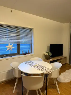 a dining room with a table and chairs and a window at Modern apartment near Oslo in Lii