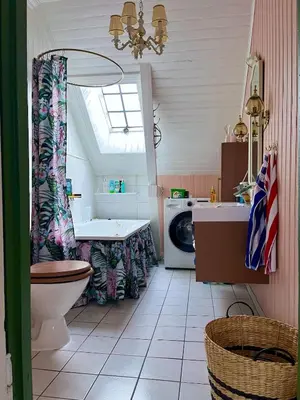 a bathroom with a sink and a washing machine at Authentic top floor pearl in the city Center in Ålesund