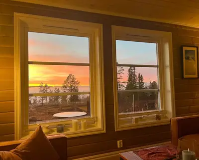 two windows in a room with a view of a sunset at Cozy family cabin with fireplace and near ski trails in Lii