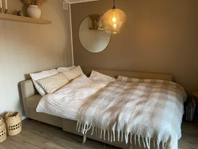 a bed with a white comforter in a bedroom at Furnished outhouse in Bergen