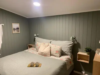 a bedroom with a bed with two candles on it at Furnished outhouse in Bergen
