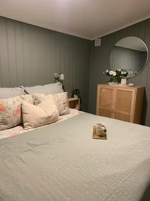 a bedroom with a large bed and a mirror at Furnished outhouse in Bergen