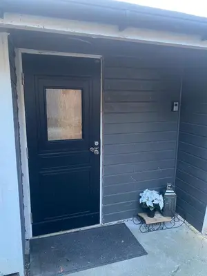 a black door with a window and a vase of flowers at Furnished outhouse in Bergen