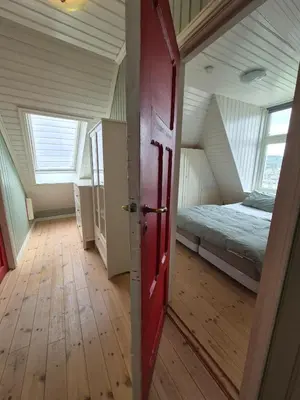 an attic room with a bed and a door at Penthouse apartment with garden and amazing view, in Bergen