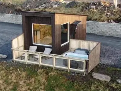 a tiny house sitting on the side of the road at Unik og moderne microhytte med utsikt mot havet 40 A in Longva