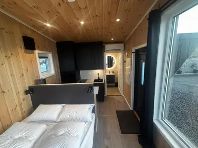 a bedroom with two beds in a tiny house at Unik og moderne microhytte med utsikt mot havet 40 A in Longva