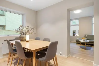 a dining room with a wooden table and chairs at Large apartment, central and quiet in Ålesund in Ålesund