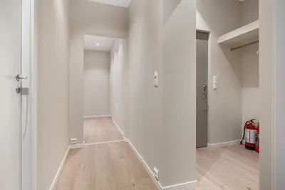 a hallway with white walls and a wooden floor at Large apartment, central and quiet in Ålesund in Ålesund