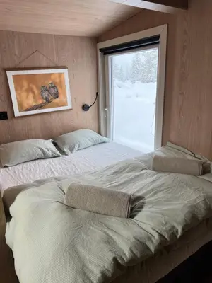 two beds in a room with a window at Retreat ved Spa hotell med Ski in & out, Norefjell in Surteberg