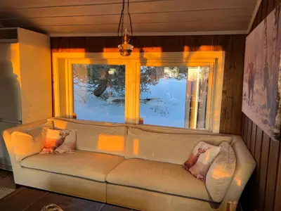a couch in a living room with a window at Retreat ved Spa hotell med Ski in & out, Norefjell in Surteberg