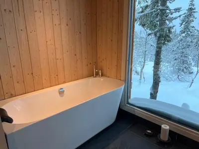 a bath tub in a room with a window at Retreat ved Spa hotell med Ski in & out, Norefjell in Surteberg