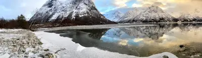 a reflection of a mountain in a body of water at Hjelledalen Hyttesenter in Hjelle