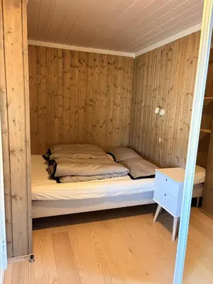 a bed in a room with a wooden wall at Apartment in the Center of Geilo in Geilo