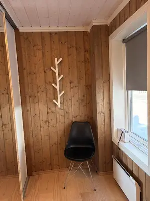 a black chair in a room with wooden walls at Apartment in the Center of Geilo in Geilo
